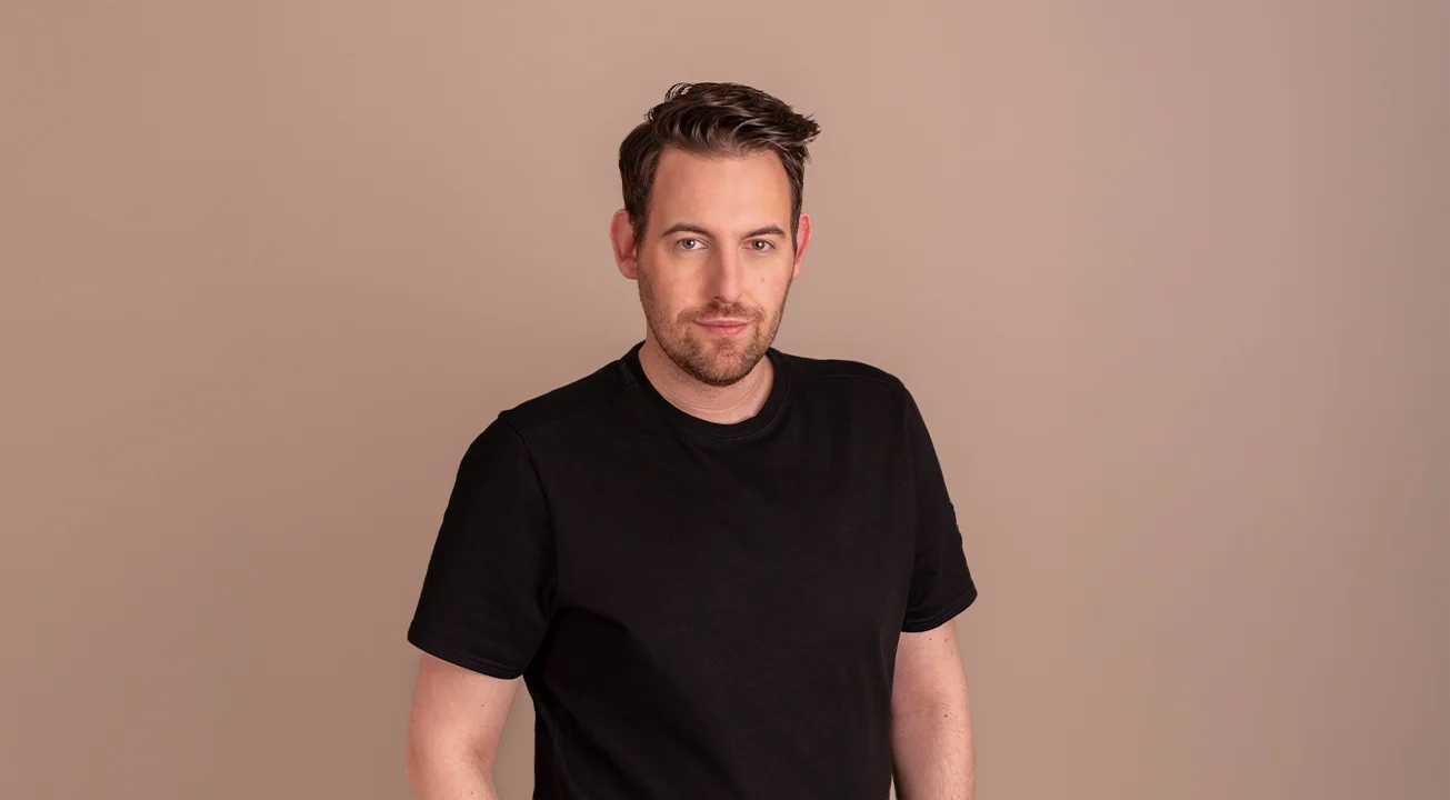 Bence Székely, Strategy Lead at Frem Digital, stands against a plain beige background, looking at the camera.