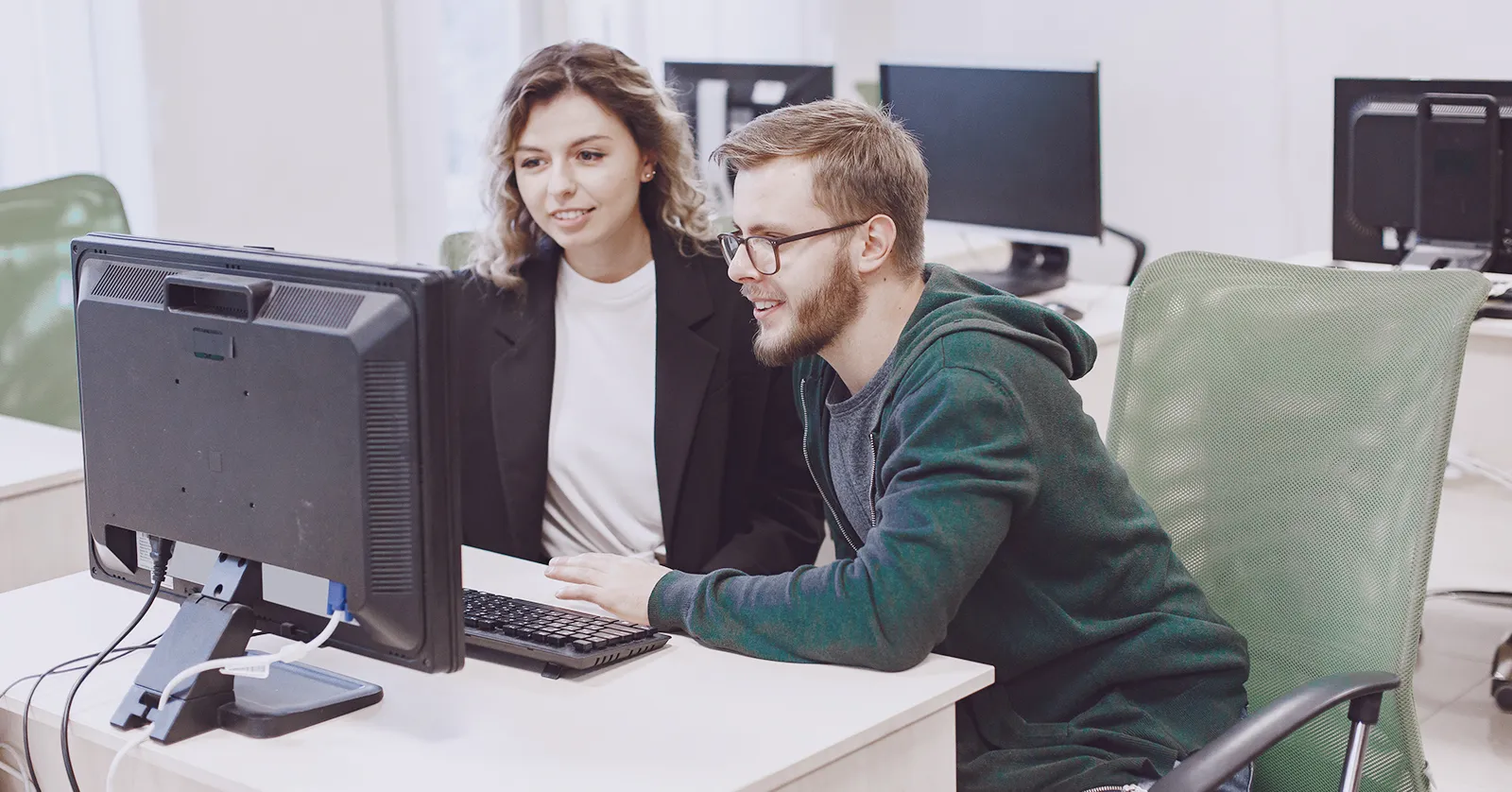 Two students at a computer, illustrating our success story of a tech course enrollment campaign.